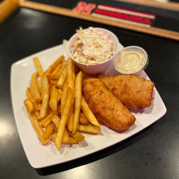 Moon Valley Grill & Patio's fish and chips with coleslaw and tartar sauce on a white plate.